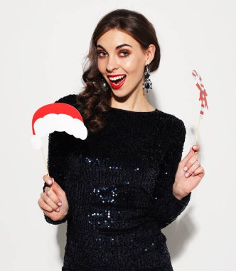 Kutlama, tatil ve insanlar konsepti - gece elbisesi giymiş neşeli esmer kadın bir parti için destek tutuyor ve gülümsüyor.