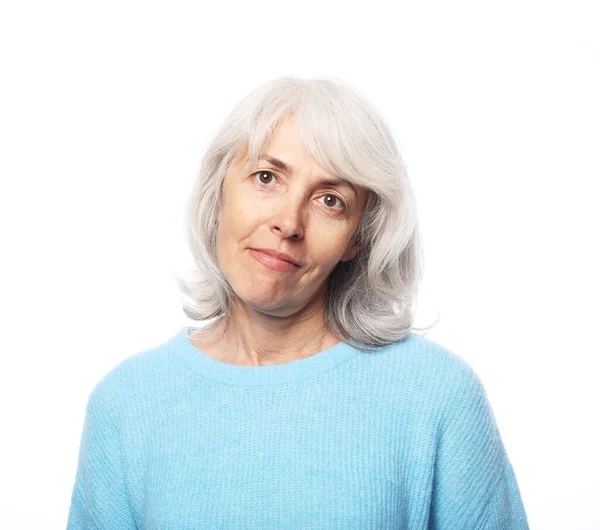 Gelukkig oudere vrouw dragen blauwe trui glimlachen over witte achtergrond, close up — Stockfoto