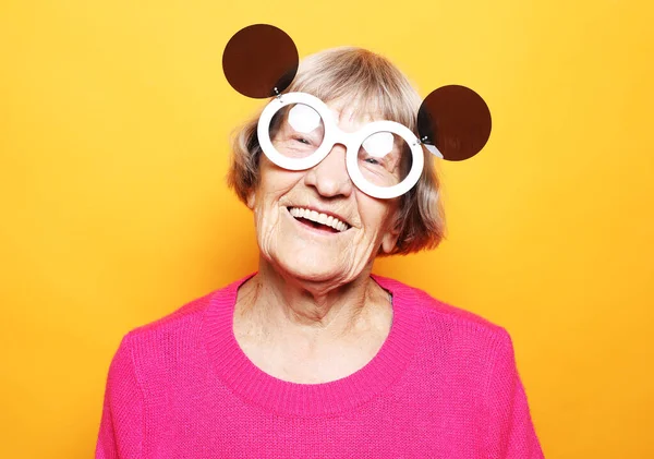 Starsza Zabawna Kobieta Ubrana Różowy Sweter Duże Okulary Przeciwsłoneczne Robi — Zdjęcie stockowe