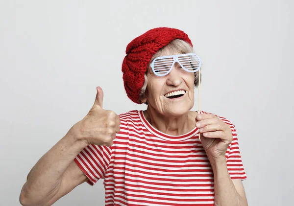 Lifestyle, emotion and people concept: funny grandmother with fake glasses, laughs and ready for party — Stock Photo, Image