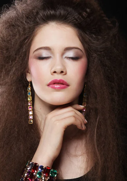 Beautiful young brunette woman with curly hair and bright make-up. — Stock Photo, Image