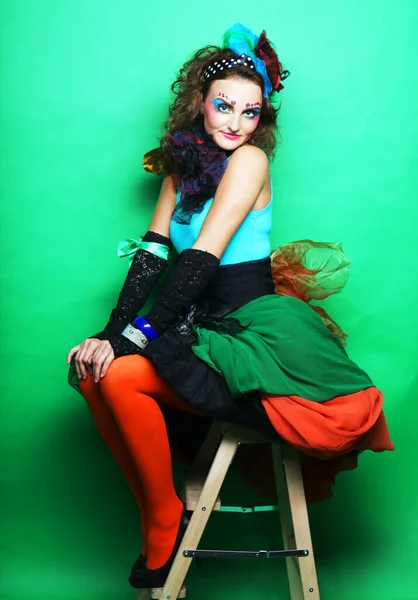 Pretty young woman in a carnival dress sits on a stool, doll style — Stock Photo, Image