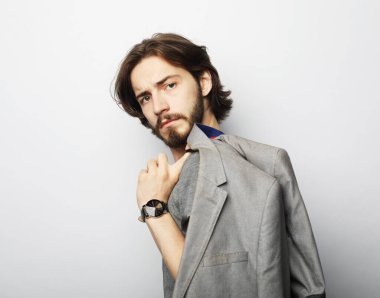 Gri arka planda genç ve yakışıklı bir adam. Stüdyo moda portresi.