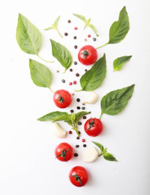 Domates, kiraz, fesleğen, baharat, biber. Beyaz üzerine izole edilmiş taze organik domatesler. Vejetaryen sebze diyeti. Fesleğen, bitki ve kiraz domatesleri, pişirme konsepti