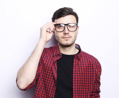 Gözlüklü genç adamın portresi gülümsüyor beyaz arka planda kameraya bakıyor..