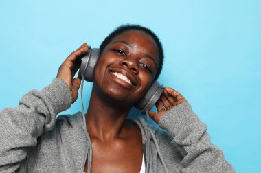 Müziğin tadını çıkar. Güzel Afrikalı genç Amerikalı kadın müzik dinliyor.