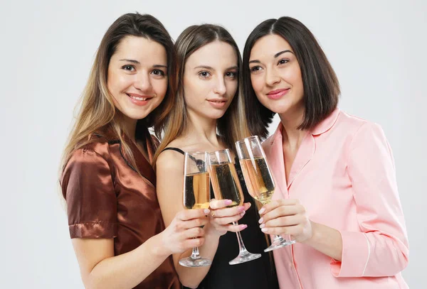 Drei junge schöne Frauen im Pyjama trinken Champagner und haben Spaß, Pyjama-Party und Freundschaftskonzept. — Stockfoto