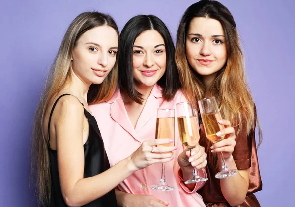 Drei junge schöne Frauen im Pyjama trinken Champagner und haben Spaß — Stockfoto