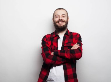 Yaşlı insanlar, duygu ve modern yaşam tarzı konsepti. Genç, gülümseyen, sakallı, sıradan giyinen, kollarını kavuşturup gri arka plan üzerinde gezen adam..