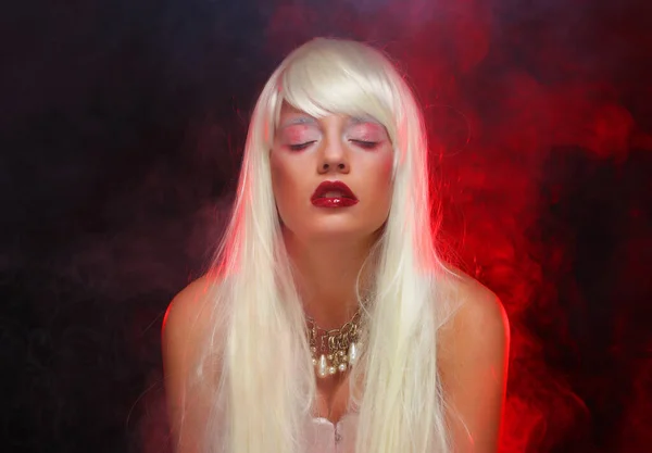 美しいハロウィン吸血鬼女性の肖像画 美白長髪のセクシーヴァンパイア魔女の女性 神秘的なモデル女の子とともにハロウィーンは赤い煙の背景を構成します — ストック写真