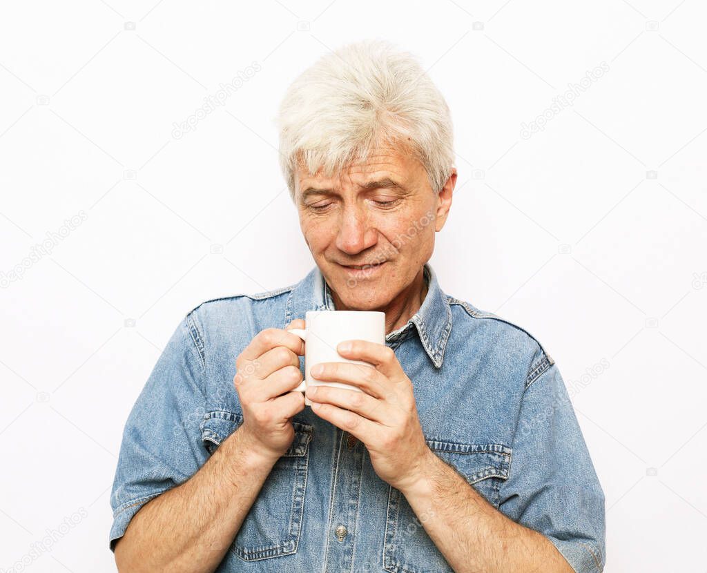 lifestyle, food and people concept: Handsome mature man hoding a cup of coffee or tea over white backgruond