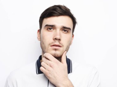 Beyaz arka planda genç ve yakışıklı bir adam.