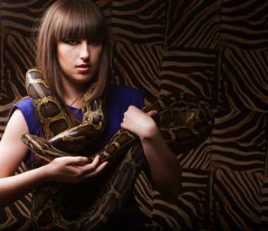 Genç seksi esmer kadın piton tutuyor, büyük yılan..