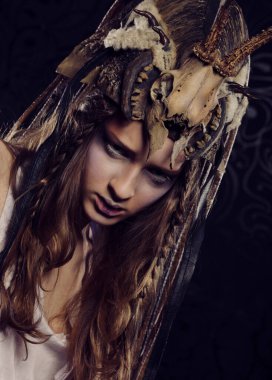 Yaratıcı saç stili ve koyu arkaplan üzerine parlak makyajlı yüksek model. Parti zamanı, karnaval ve Cadılar Bayramı teması.