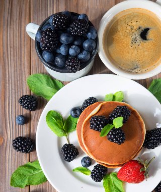 Kahvaltıda böğürtlenli ve çilekli krep. Yumuşak ve lezzetli krep. Güzel ve sağlıklı taze yiyecekler. Böğürtlenli ev kahvaltısı. Üst manzara, düz uzanma.