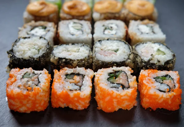 Japanese food. Sushi. Philadelphia roll with fresh salmon, cucumber, avocado, cream cheese, tobiko caviar. Close up.