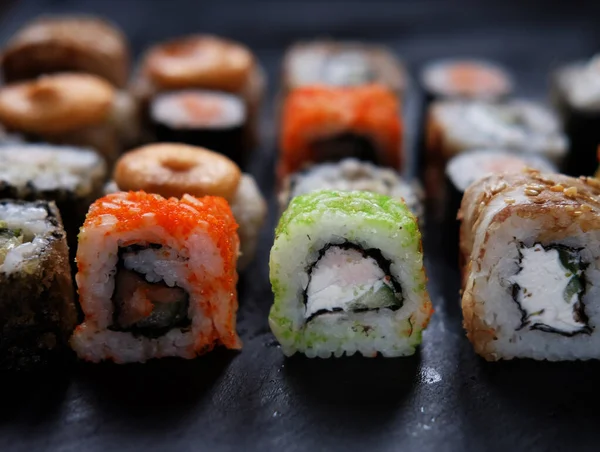 Japanese food. Sushi. Philadelphia roll with fresh salmon, cucumber, avocado, cream cheese, tobiko caviar. Close up.