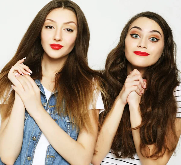 Estilo de vida y el concepto de la gente: Dos amigas jóvenes de pie a — Foto de Stock