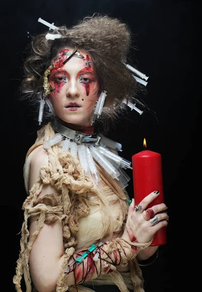 Νεαρή γυναίκα με δημιουργικό μακιγιάζ και χτένισμα κρατώντας ένα κερί. Απόκριες θέμα. — Φωτογραφία Αρχείου