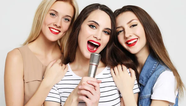 Skönhet flickor med en mikrofon sjunga och ha kul tillsammans — Stockfoto