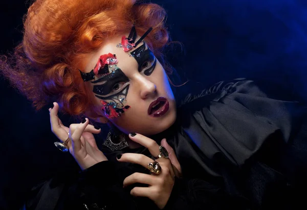 Uma jovem ruiva disfarçada de bruxa. Maquiagem criativa para mascarada. — Fotografia de Stock
