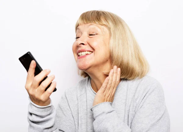老年妇女使用电话和微笑 — 图库照片