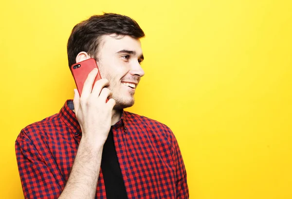 Tehnologie, emotie en people concept: jonge man die met smartphone praat en naar de camera kijkt — Stockfoto