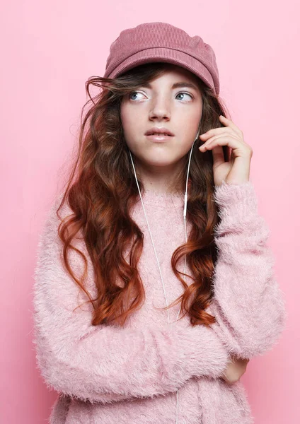 Ragazza carino bambino indossare cuffie ascoltare musica. Ragazzo ascoltare musica rosa sfondo. — Foto Stock