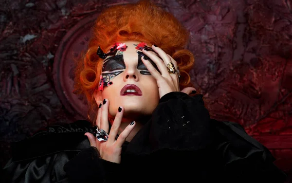 Červenovlasá mladá žena v kostýmu čarodějnice. Kreativní make-up pro maškarní. — Stock fotografie