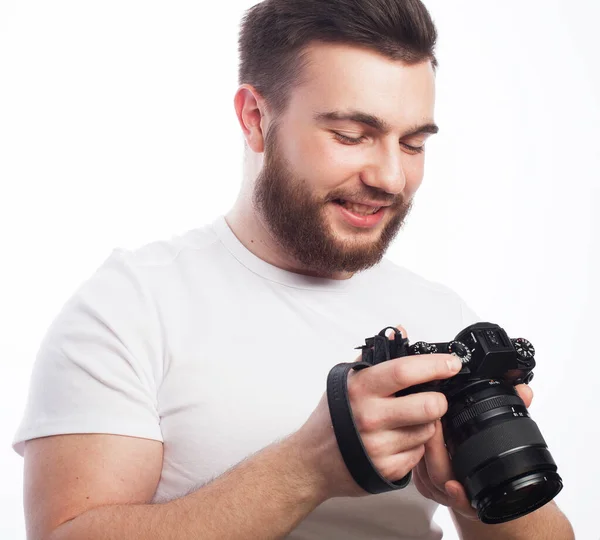 Young bearded photographer wearing glasses looking at photos on the camera screen — Stock Photo, Image