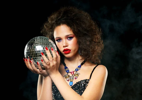 Mode et concept de personnes : Portrait de jeune femme africaine avec maquillage créatif tenant le ballon disco — Photo