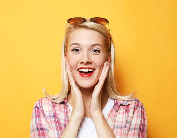 Mujer joven y emotiva sonríe y toca su cara. Felicidad y alegría. Concepto de estilo de vida y personas. — Foto de Stock