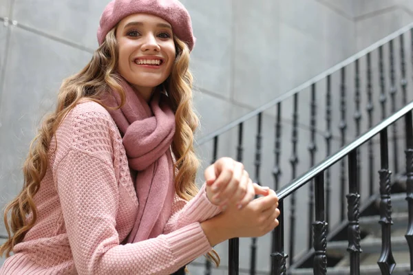 Young beautiful woman stands by the stairs — Stock Photo, Image