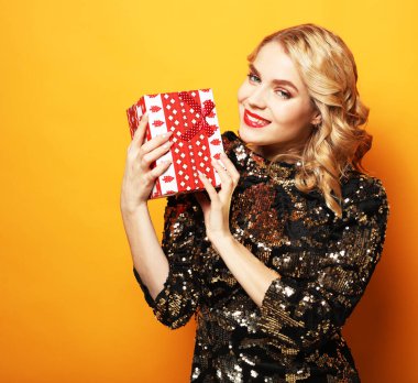 Kutlama partisinde üzerinde hediye kutusu olan ışıltılı bir elbise giyen güzel bir kadın. Yeni Yıl Gecesi Kutlaması