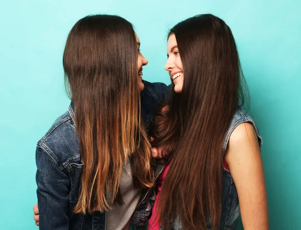 Životní styl, lidé, dospívající a přátelství koncept - šťastný úsměv hezká dospívající dívky nebo přátelé objímání přes modré pozadí — Stock fotografie
