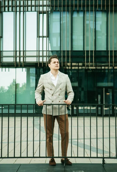 Business, people and success concept: Handsome man in fashinable outfit walking near modern office — Stock Photo, Image