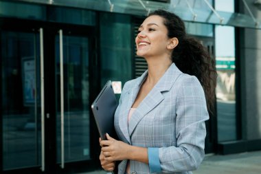 İş dünyası, insanlar ve başarı kavramı: Genç Afrikalı Amerikalı kadın dışarıda dizüstü bilgisayar kullanıyor