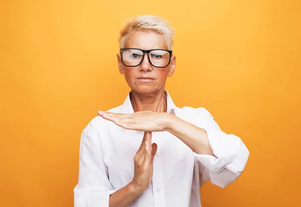 Gesture, prohibition and old people concept: Senior woman with short grey hair making time out sign — Stock Photo, Image