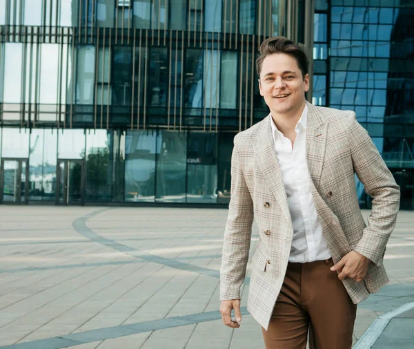 Negocios, personas y concepto de éxito: Hombre guapo en traje fashinable caminando cerca de la oficina moderna —  Fotos de Stock