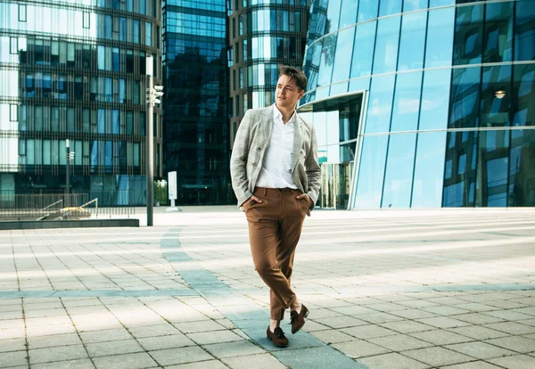 Negocios, personas y concepto de éxito: Hombre guapo en traje fashinable caminando cerca de la oficina moderna —  Fotos de Stock