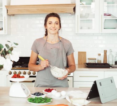 Genç kadın pasta şefi kremayla çalışıyor. Lezzetli hamur işleri. Hobi olarak. Küçük ev işleri..