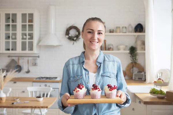 Lifestyle, food, people and small business concept: Young baker woman holding cupcakes. — Stock Photo, Image