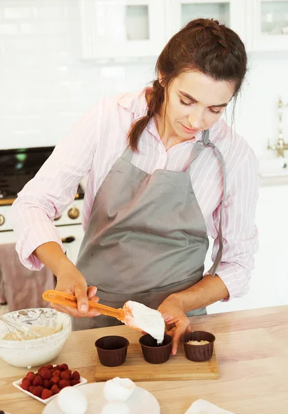 Young woman pastry chef works with cream. Delicious pastries. Hobby. Small home business.