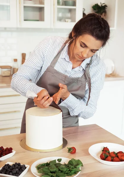 Lifestyle, food, people concept: Pastry chef in the kitchen decorating a cake of chocolate — Stock Photo, Image