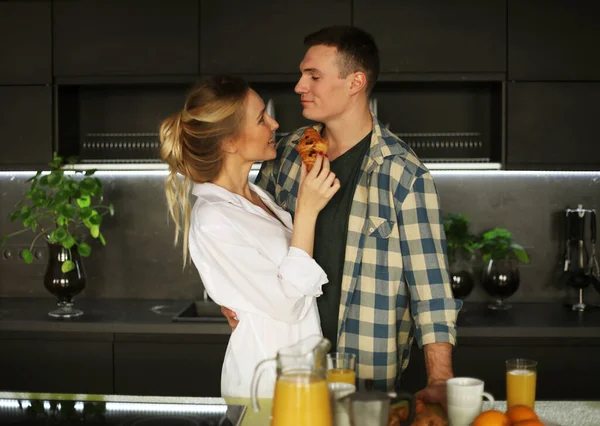 Encantador jovem casal de pé e abraçando em uma cozinha em casa — Fotografia de Stock