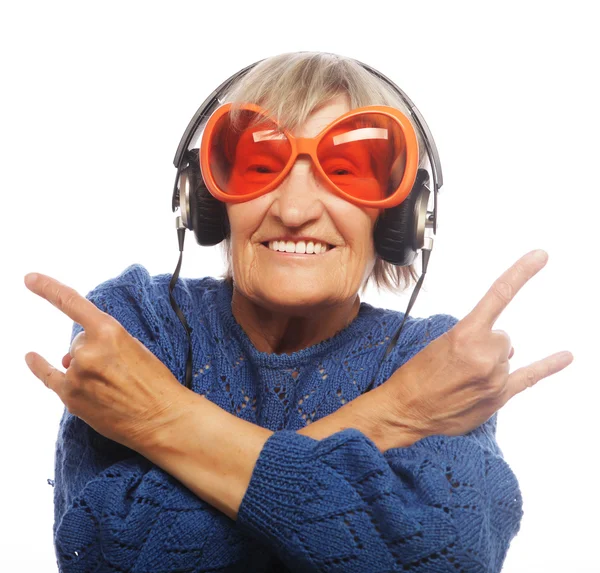 Funny old lady listening music and showing thumbs up. — Stock Photo, Image