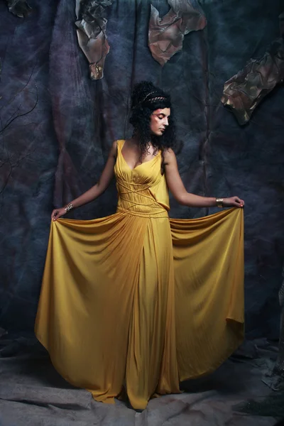 Mulher morena usando vestido de noite amarelo — Fotografia de Stock