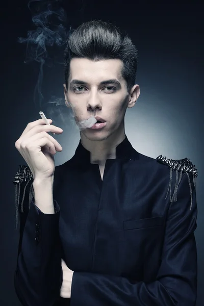 Jovem homem elegante fumar um cigarro — Fotografia de Stock