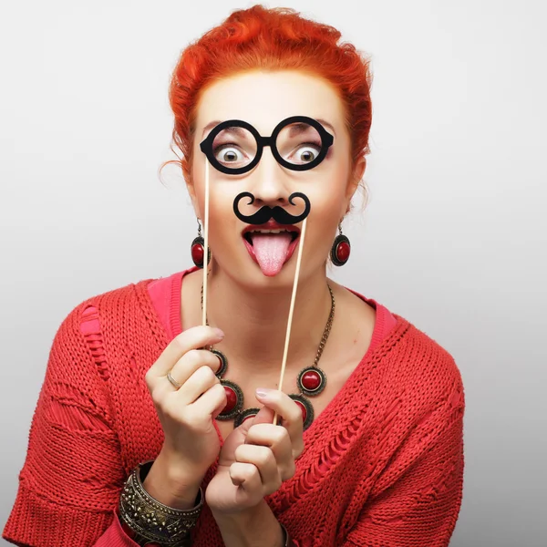 Woman holding mustache and glasses on a stick. — Stock Photo, Image