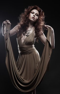 Bej renkli uzun elbiseli genç kadın.